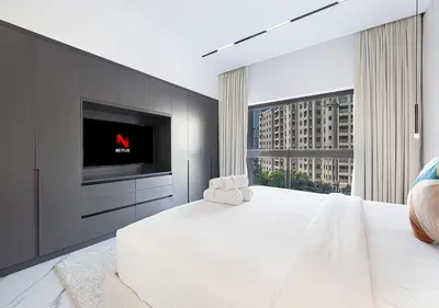 a bedroom with a large white bed and a tv at Palm Jumeirah Paradise- Luxury,Unveiled in Dubai