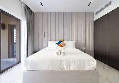 a bedroom with a large white bed with two towels at Palm Jumeirah Paradise- Luxury,Unveiled in Dubai