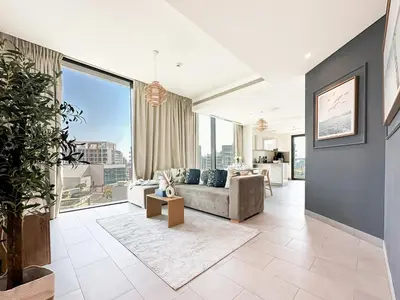 a living room with a couch and large windows at Trophy - Alfresco 2BDR Suite in Dubai