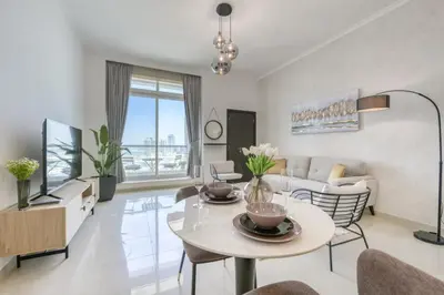 a living room with a table and a couch at Spacious 1BR in Botanica tower with sea view by PK holidays in Dubai