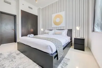 a bedroom with a large bed with white sheets at Spacious 1BR in Botanica tower with sea view by PK holidays in Dubai