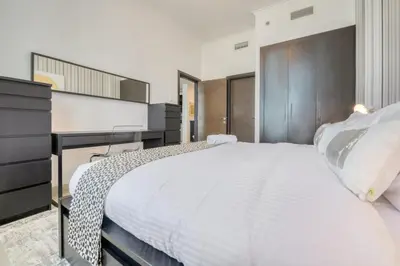a bedroom with a large white bed and a dresser at Spacious 1BR in Botanica tower with sea view by PK holidays in Dubai