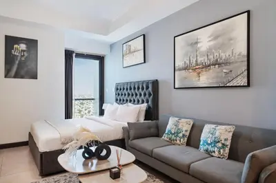a living room with a bed and a couch at Modern Studio Lake View JLT Near Marina & Metro in Dubai