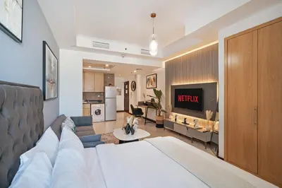 a living room with a bed and a kitchen at Modern Studio Lake View JLT Near Marina & Metro in Dubai