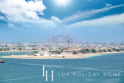 a view of a beach with a city in the background at LUX The Beachfront Island View Suite in Dubai
