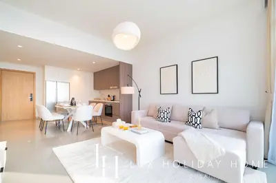 a living room with a couch and a table at LUX The Beachfront Island View Suite in Dubai
