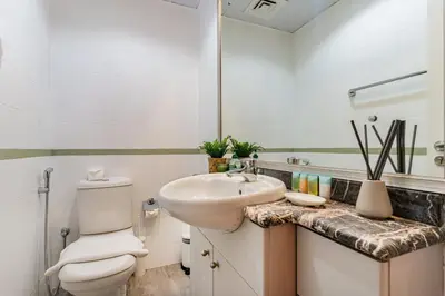 a bathroom with a sink and a toilet and a mirror at Lake Apartments - 1BR Apartment - Allsopp&Allsopp in Dubai