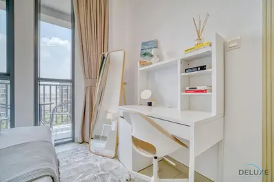a white bedroom with a desk and a bed and a window at Serene 1BR at Afnan 3 Midtown Dubai Production City by Deluxe Holiday Homes in Dubai