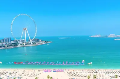 a view of a beach with a ferris wheel at Stunning Beach front Apt Dubai Eye View JBR Dubai in Dubai