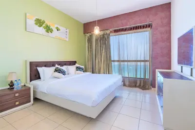 a bedroom with a large bed and a window at Stunning Beach front Apt Dubai Eye View JBR Dubai in Dubai