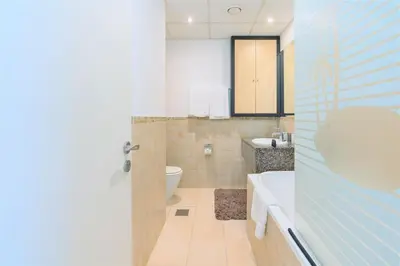 a bathroom with a tub and a toilet and a sink at Stunning Beach front Apt Dubai Eye View JBR Dubai in Dubai