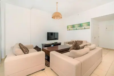 a living room with two couches and a table at Stunning Beach front Apt Dubai Eye View JBR Dubai in Dubai