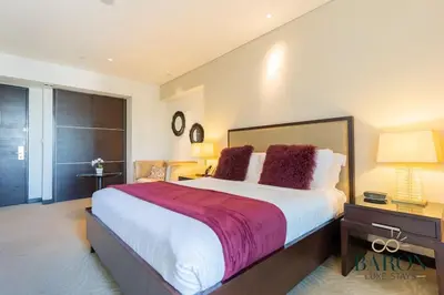 a bedroom with a large white bed with red pillows at The Urban in Dubai