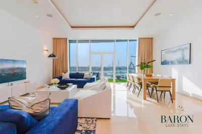 a living room with a blue couch and a table at The Grand Palm Suite Oceana in Dubai
