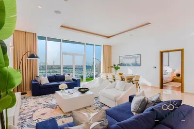 a living room with blue and white furniture and glass windows at The Grand Palm Suite Oceana in Dubai