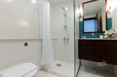 a bathroom with a shower and a toilet and a mirror at The Grand Palm Suite Oceana in Dubai