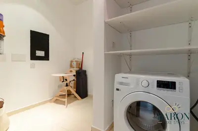 a laundry room with a washing machine in it at The Grand Palm Suite Oceana in Dubai