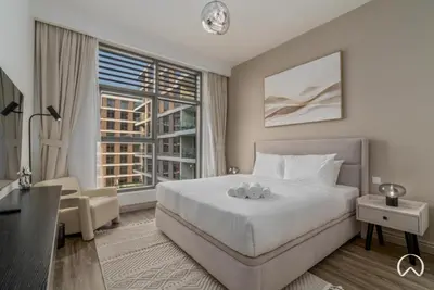 a bedroom with a large bed and a large window at Oraya - Stunning 2BR- Mulberry Dubai Hills, Pool-Park view in Dubai