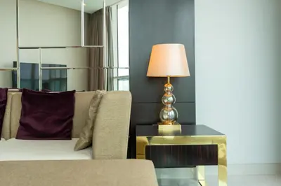 a living room with a couch and a lamp on a table at Lux BnB Upper Crest Tower I Skyline Views in Dubai