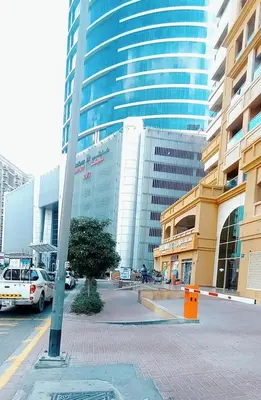 a city street with tall buildings and a pole at Luxurious Partition Room in Tecom Near Internet City Metro Station in Dubai