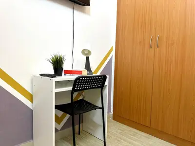 a desk with a chair next to a cabinet at Double window Partition Room in Tecom Near Metro in Dubai