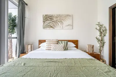 a bedroom with a bed with a green blanket at GuestReady - Full Marina View at Bay Central in Dubai
