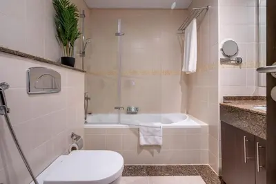 a bathroom with a tub and a toilet and a sink at GuestReady - Full Marina View at Bay Central in Dubai