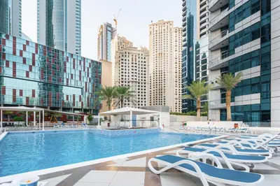 a swimming pool with lounge chairs and buildings at GuestReady - Full Marina View at Bay Central in Dubai