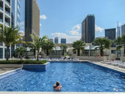 a woman in a swimming pool in a city at GuestReady - Full Marina View at Bay Central in Dubai