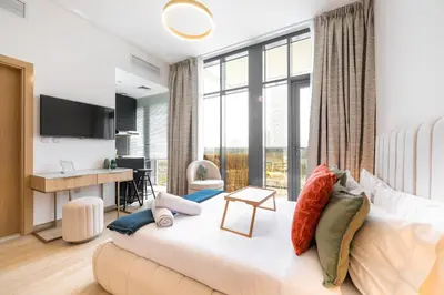 a living room with a large bed and a desk at Daniels Cozy Studio at JVC in Dubai