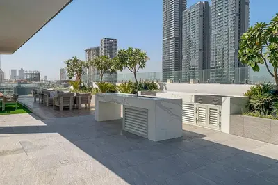 a rooftop patio with tables and a view of a city at Frank Porter - Oxford 212 in Dubai