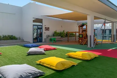 a group of five different colored pillows on a green carpet at Frank Porter - Oxford 212 in Dubai