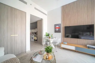 a living room with a large television and a table at Frank Porter - Oxford 212 in Dubai