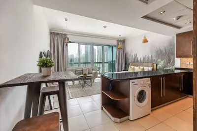 a kitchen and living room with a washer and dryer at Spacious Studio in Downtown I 8 Boulevard Walk in Dubai