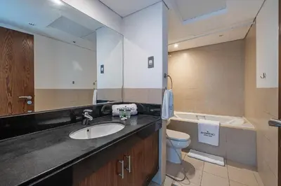 a bathroom with a sink and a toilet and a mirror at Spacious Studio in Downtown I 8 Boulevard Walk in Dubai
