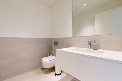 a bathroom with a toilet and a sink and a mirror at Sunset at Creek Beach - Exquisite Two Bedroom in Dubai