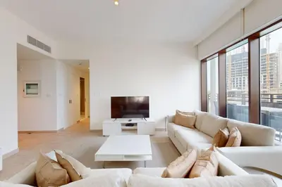 a living room with white furniture and a flat screen tv at Sunset at Creek Beach - Exquisite Two Bedroom in Dubai