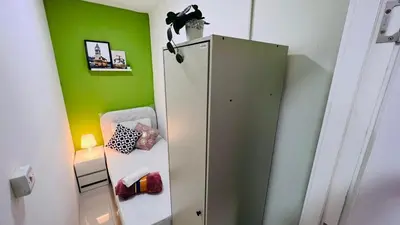 a white refrigerator in a room with a green wall at Best Closed Partition Room in Al Barsha-1 Near MOE Metro in Dubai