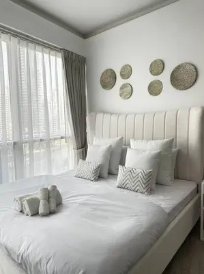 a white bed with a teddy bear sitting on it at 2 BDR in Marina Terrace Dubai Marina in Dubai
