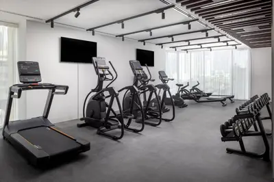 a gym with several exercise bikes and a flat screen tv at Holiday Inn Dubai Business Bay by IHG in Dubai