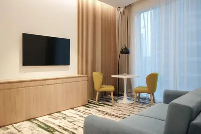 a living room with a couch and chairs and a tv at Holiday Inn Dubai Business Bay by IHG in Dubai