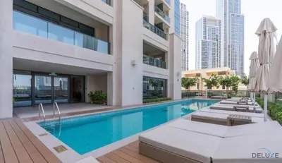 a swimming pool in a building with chairs and umbrellas at Sumptuous 1BR at Act One Act Two Tower 1 Downtown Dubai by Deluxe Holiday Homes in Dubai