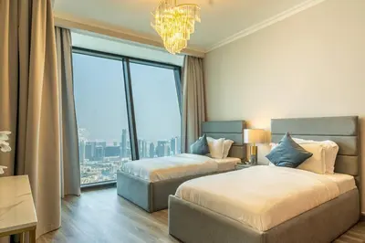 a hotel room with two beds and a large window at Downtown 3BR Luxe, Burj & Fountain View Bliss Near Dubai Mall in Dubai