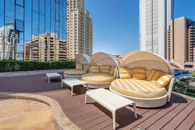 a rooftop deck with couches and chairs on a building at GuestReady - Lux home with sea view balcony in Dubai