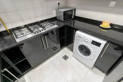 a kitchen with a stove and a washing machine at Group Stay I Near Dubai Mall I Family friendly in Dubai