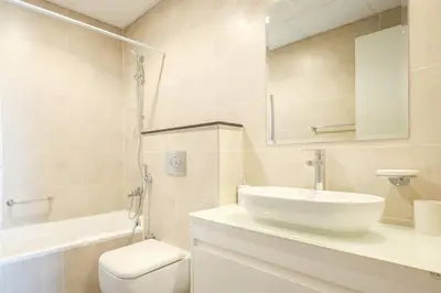 a bathroom with a sink and a toilet and a mirror at Elite LUX Holiday Homes - Serene Golf View Living 1 BHK in Damac Hills, Dubai in Dubai