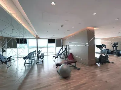 a gym with exercise equipment in a building at Elite LUX Holiday Homes - Serene Golf View Living 1 BHK in Damac Hills, Dubai in Dubai