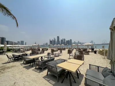a group of tables and chairs on the beach at Chic Palm Studio with Sea View & Infinity Pool in Dubai