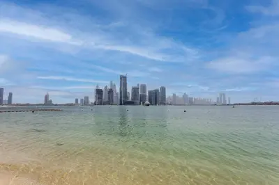 a view of a beach with a city in the background at Chic Palm Studio with Sea View & Infinity Pool in Dubai