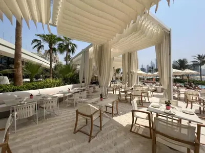 a restaurant with white tables and white chairs at Chic Palm Studio with Sea View & Infinity Pool in Dubai